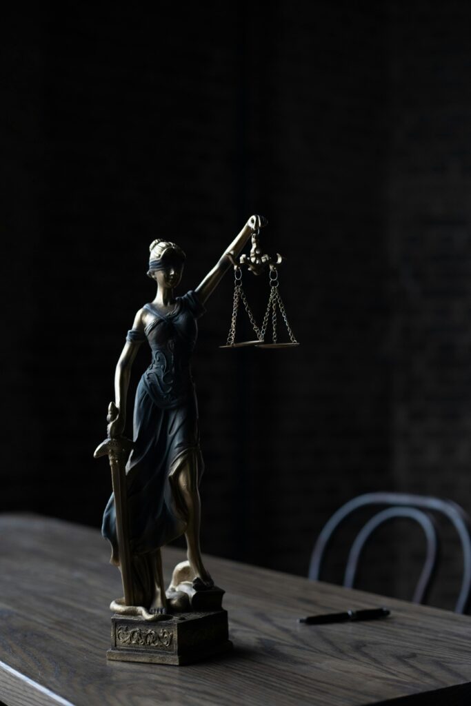 pexels-photo-6077430-6077430 Dramatic lighting on Lady Justice figurine, symbolizing law and fairness.